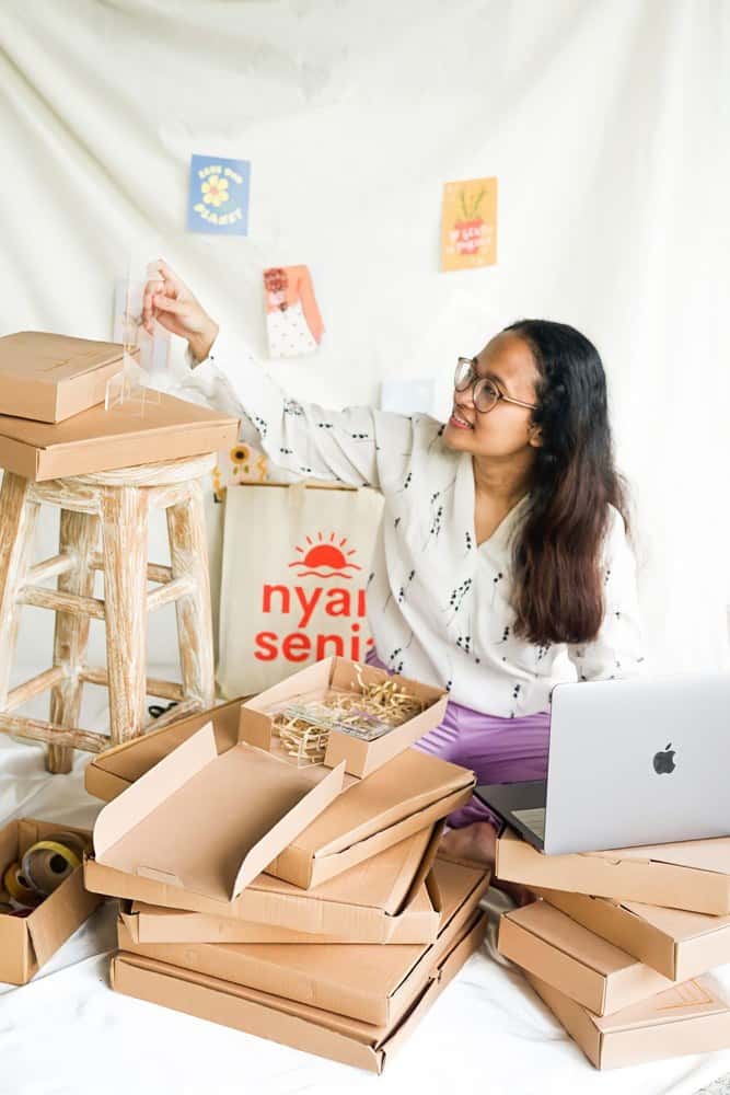 A business owner preparing customer orders beside her laptop