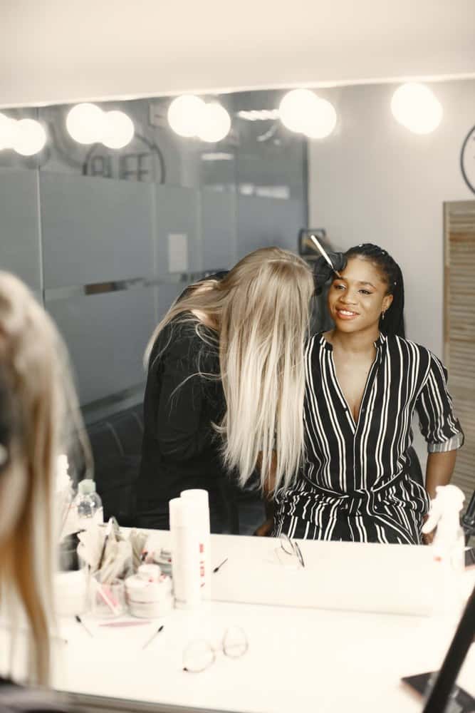 A beauty professional working with a client in a salon